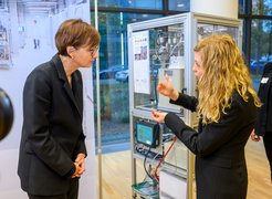 Ministerin Stark-Watzinger wird in die Forschung zur Wasserstoffumwandlung eingeführt. Katarzyna Skorupska (FHI) erklärt die Prozesse im chemischen Reaktor.